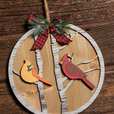 10 inch circular sign with birds hanging on a dark wooden background.