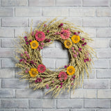 22" wreath made of purple globe amaranthus and Avena oats, along with the sweet zinnia flowers on a white brick background. 