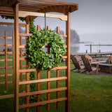 Hand picked fresh salal wreath shown on wooden arbor