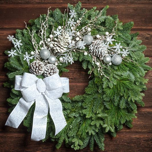 White decor with white bow on evergreen wreath