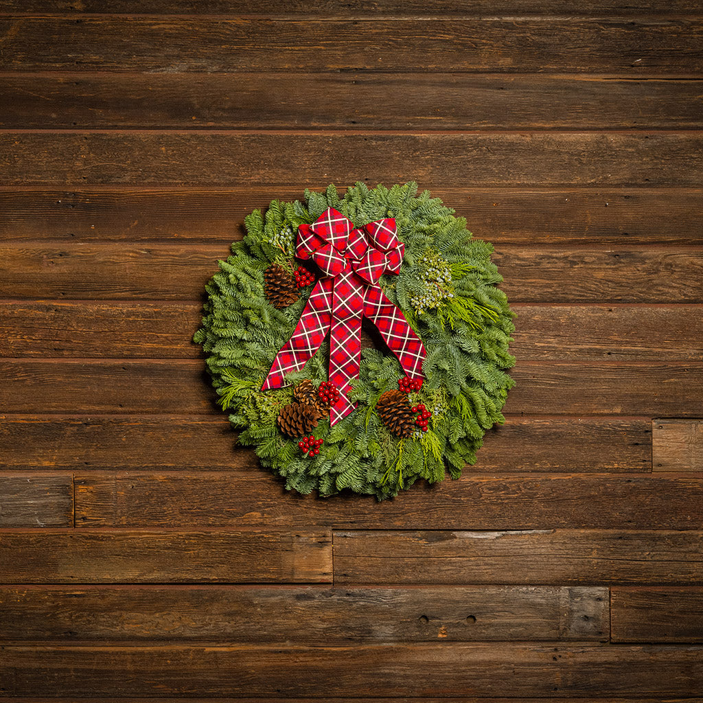 Christmas wreath with a red bow on a wooden background