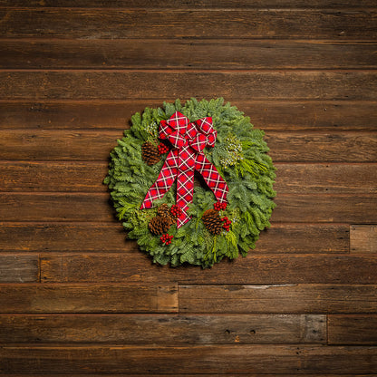 Christmas wreath with a red bow on a wooden background