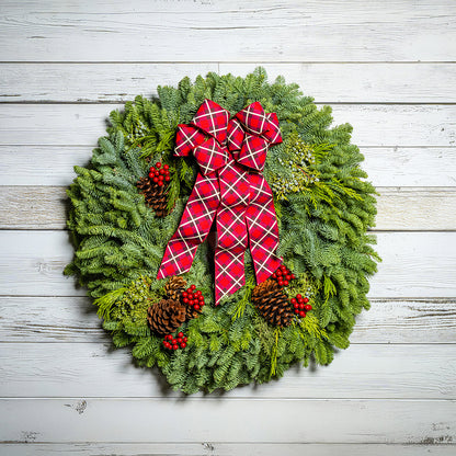 Christmas wreath with a red plaid bow on a wooden background