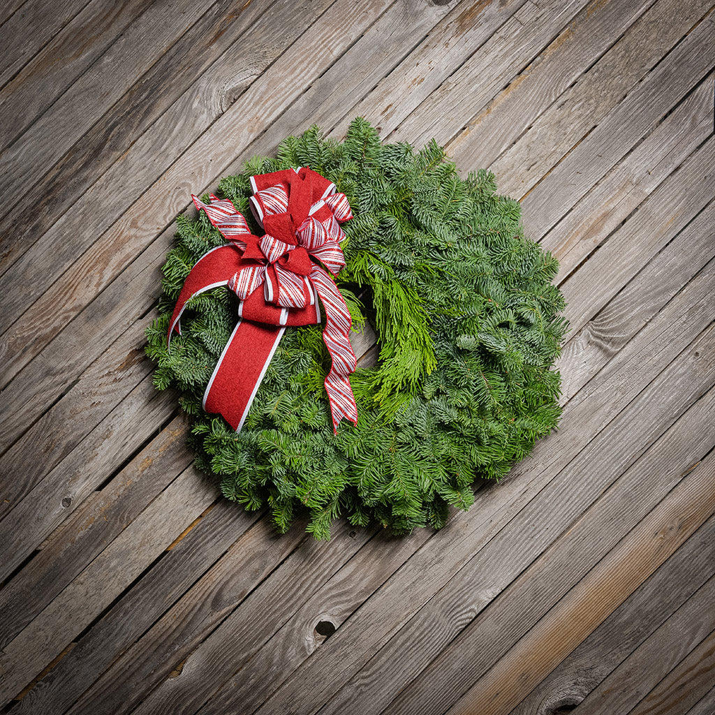 Christmas wreath with a red bow on a wooden surface