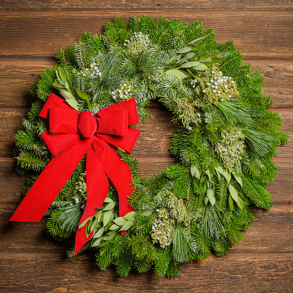 Christmas wreath with a red bow on a wooden background