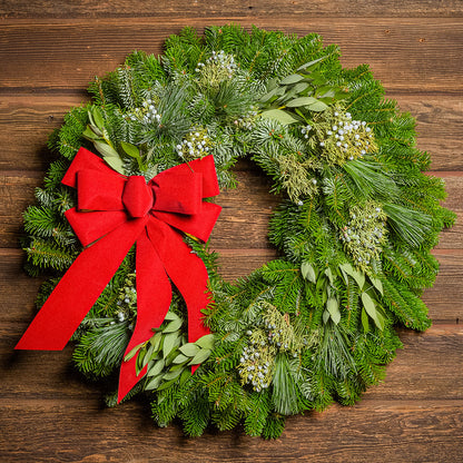 Christmas wreath with a red bow on a wooden background