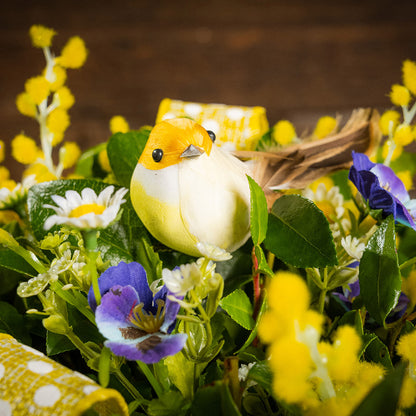 Fresh salal and green huckleberry with faux pansies, and faux yellow Alstromeria lilies, and a yellow bird.