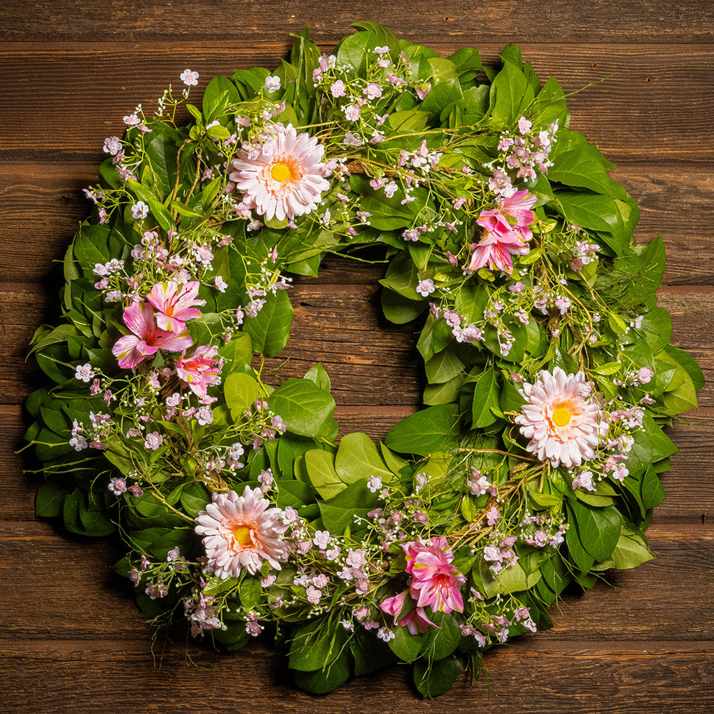 Fresh salal and sweet huckleberry with faux pink gerbera daisies, pink fairy blossoms, and pink alstroemeria flowers