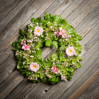 Fresh salal and sweet huckleberry with faux pink gerbera daisies, pink fairy blossoms, and pink alstroemeria flowers