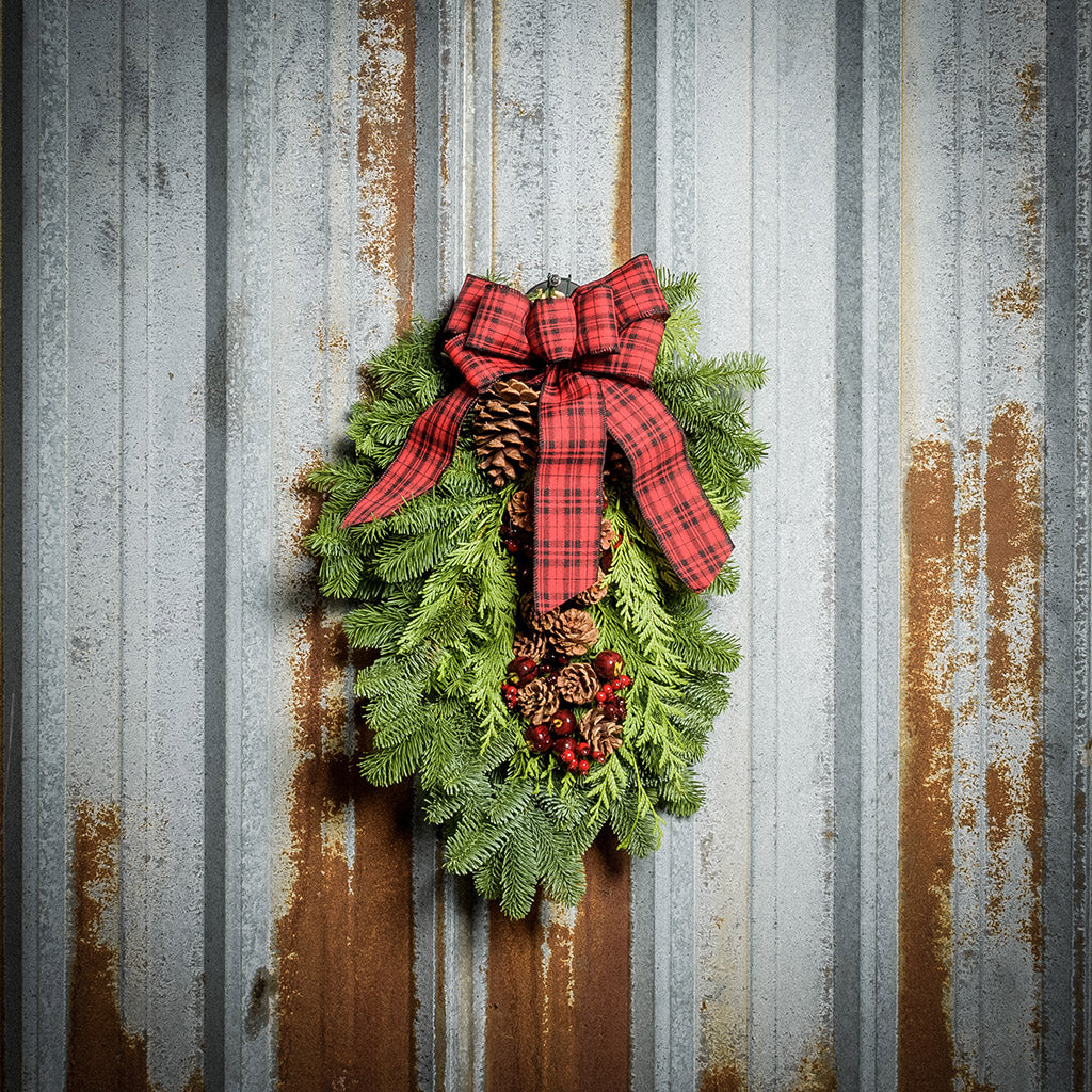 Christmas Swag made with fir cedar juniper pine cone glittery branches silver balls and red and plaid bow