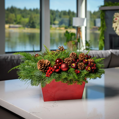 Centerpiece made of noble fir, cedar, and pine with Australian pine cones, red berry clusters, apple/pine cone picks, and a red metallic container