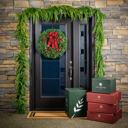 Christmas wreath made of noble fir and variegated holly with 4 country-berry clusters and a red brushed-linen bow