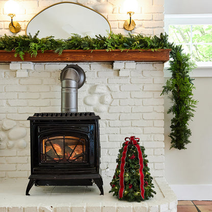 Fresh hand-assembled tabletop Christmas tree with fir, variegated holly, red berries and a red velveteen bow and white LEDs