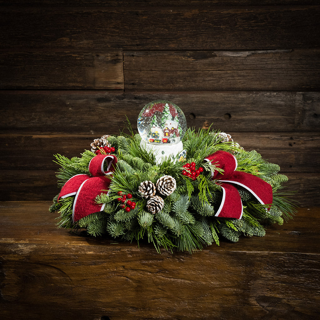 noble fir, cedar, and white pine with frosted pinecones, faux red berries, red brushed-linen bow tucks, and a light-up snowglobe