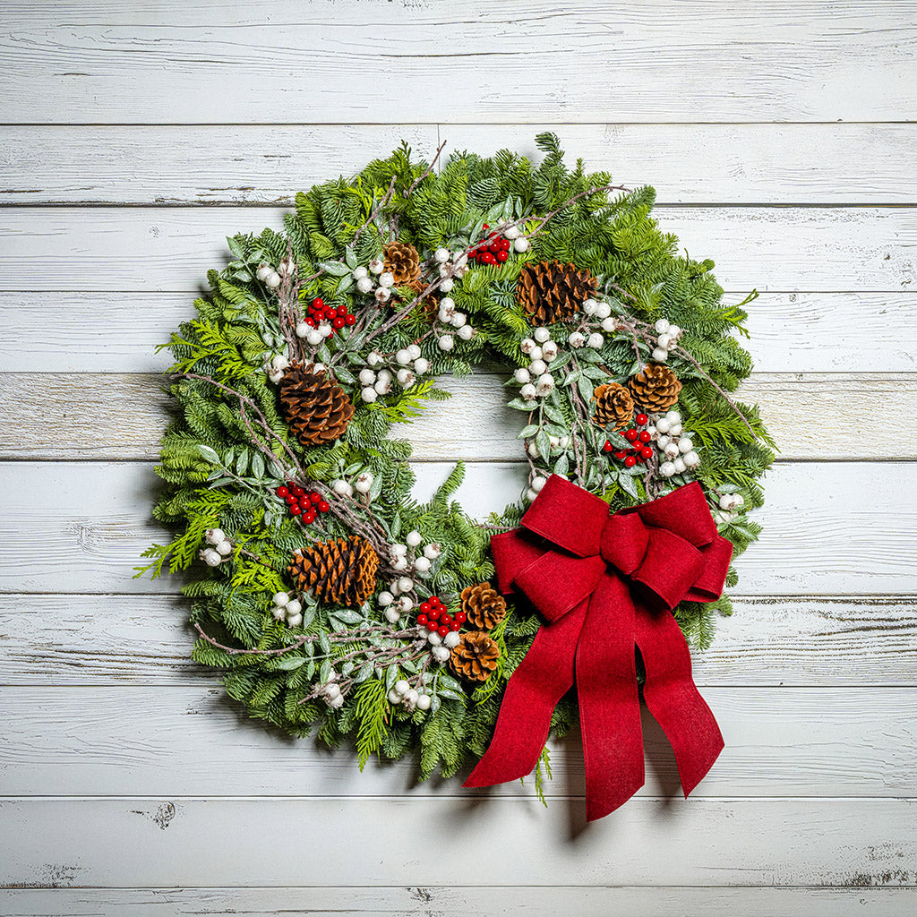 Christmas wreath with a red bow on a wooden background