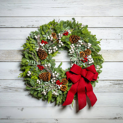 Christmas wreath with a red bow on a wooden background