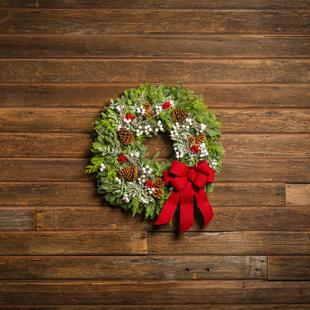 Christmas wreath with red bow on a wooden background
