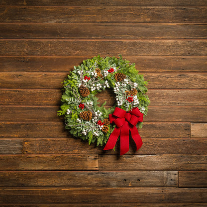 Christmas wreath with red bow on a wooden background