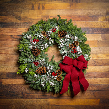 Christmas wreath with red bow on a wooden background