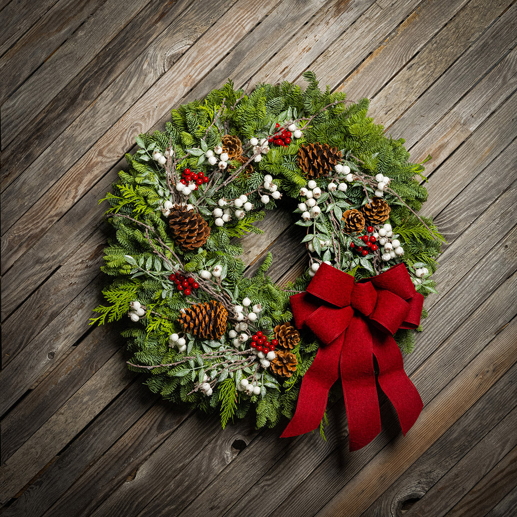 Christmas wreath with red bow on a wooden background