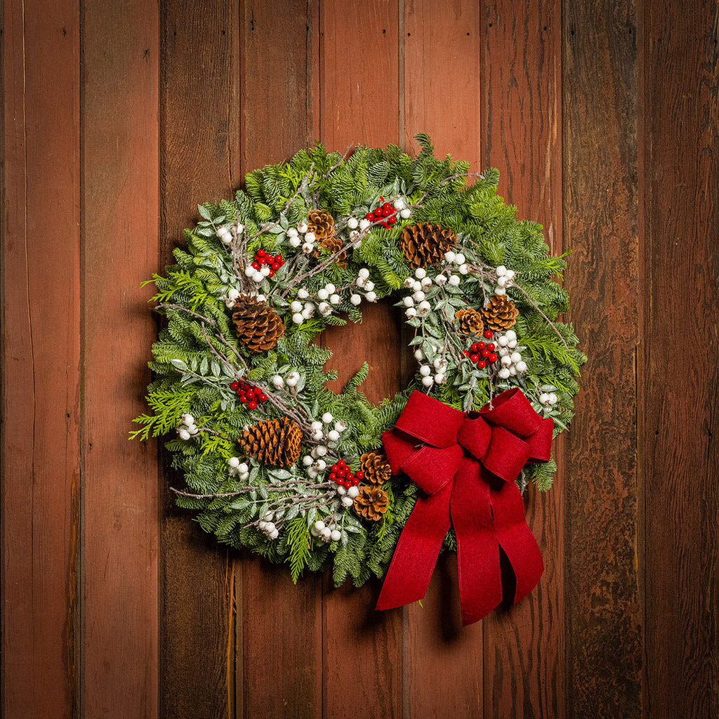 Christmas wreath with red bow on a wooden door