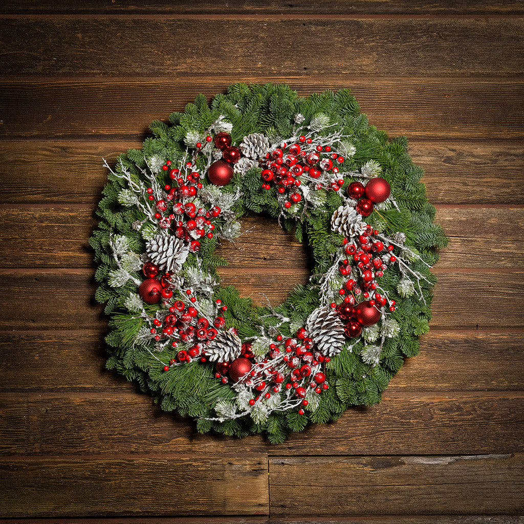 Red frosted berries and red balls on evergreen wreath