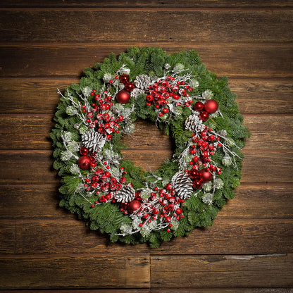 Red frosted berries and red balls on evergreen wreath