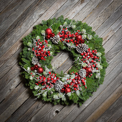 Red frosted berries and red balls on evergreen wreath