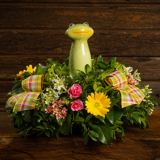 Fresh salal and green huckleberry with faux yellow daisies, faux pink wax flowers, faux mini roses, faux variegated greens, plaid bows, and a ceramic frog decoration