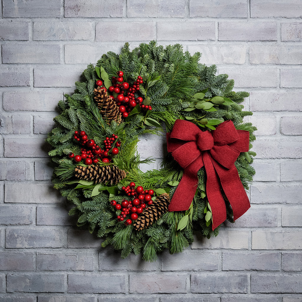 Red Berries and red linen bow on evergreen wreath