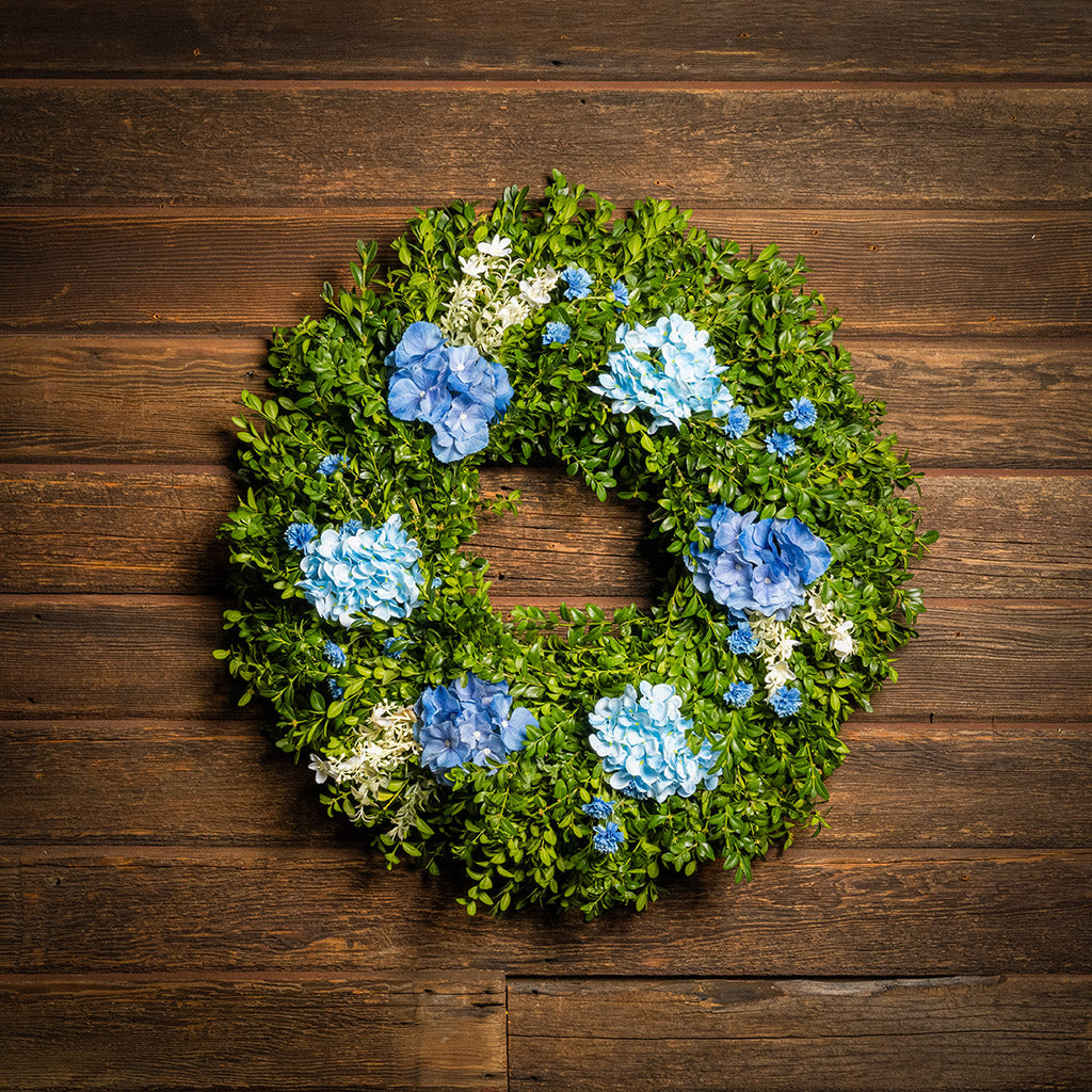 Fresh boxwood with faux blue hydrangeas and blue statice flowers