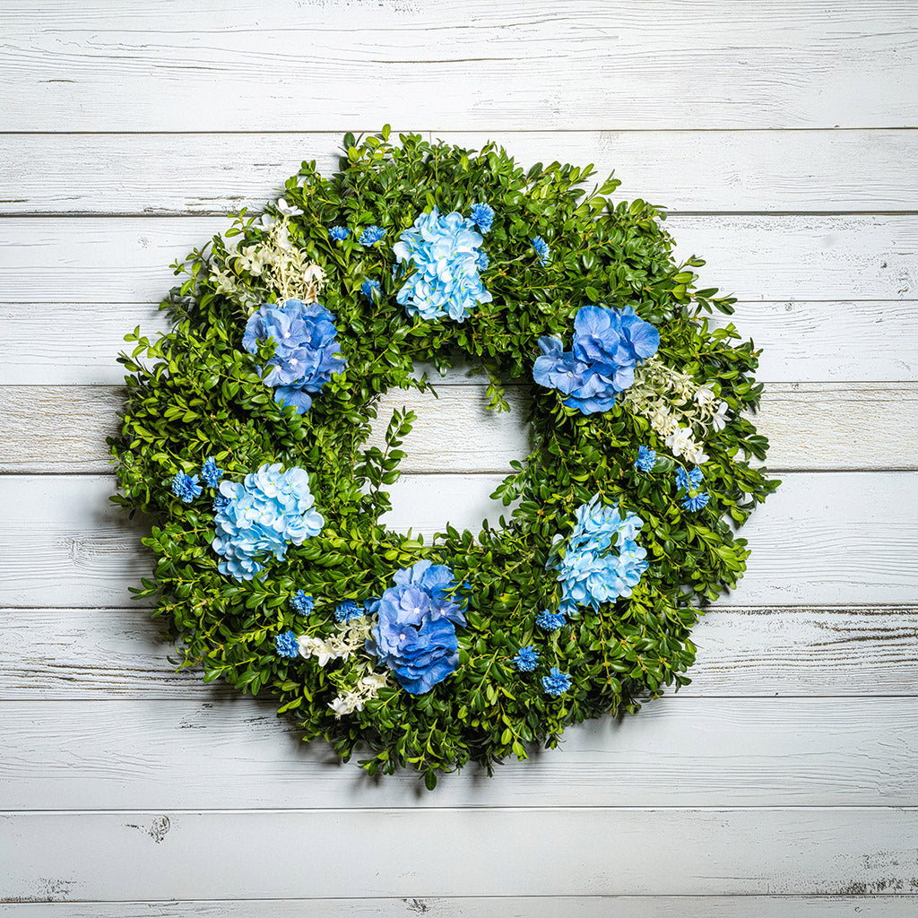 Fresh boxwood with faux blue hydrangeas and blue statice flowers