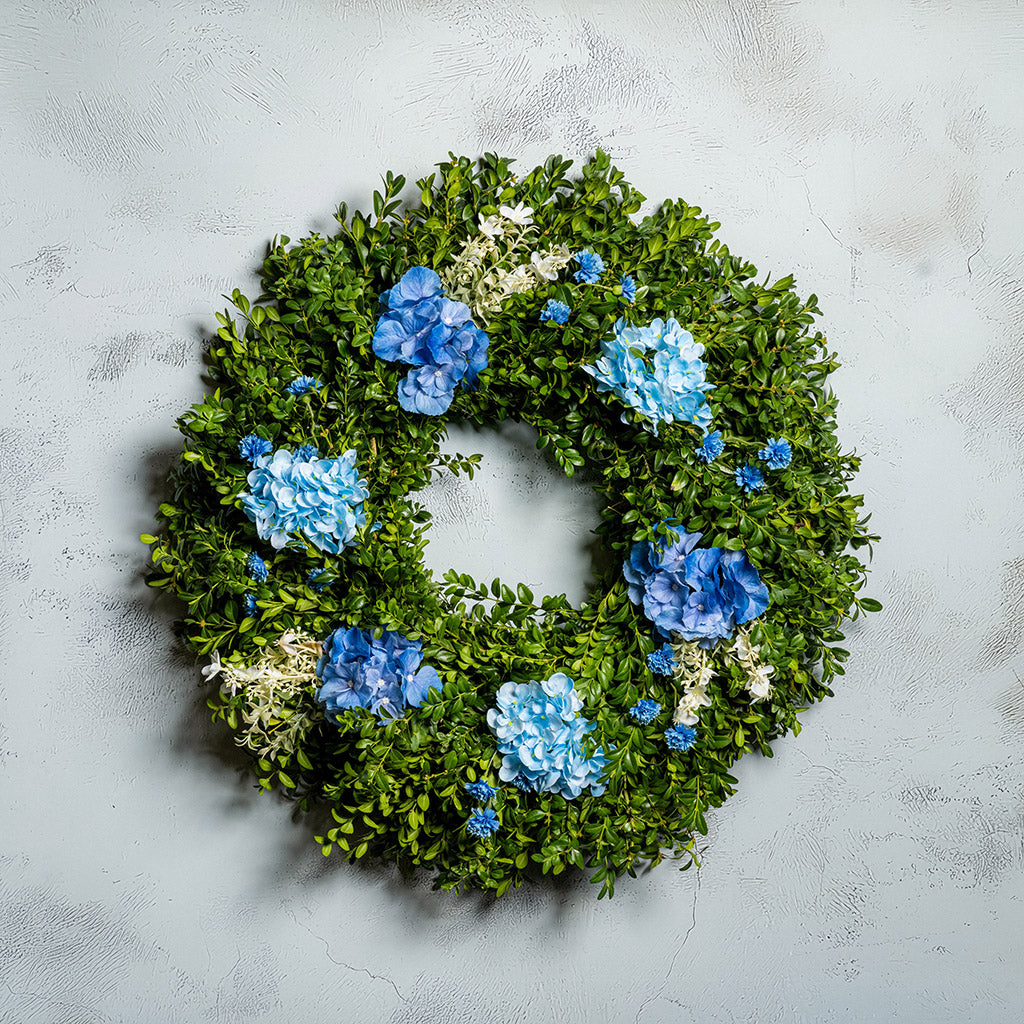 Fresh boxwood with faux blue hydrangeas and blue statice flowers