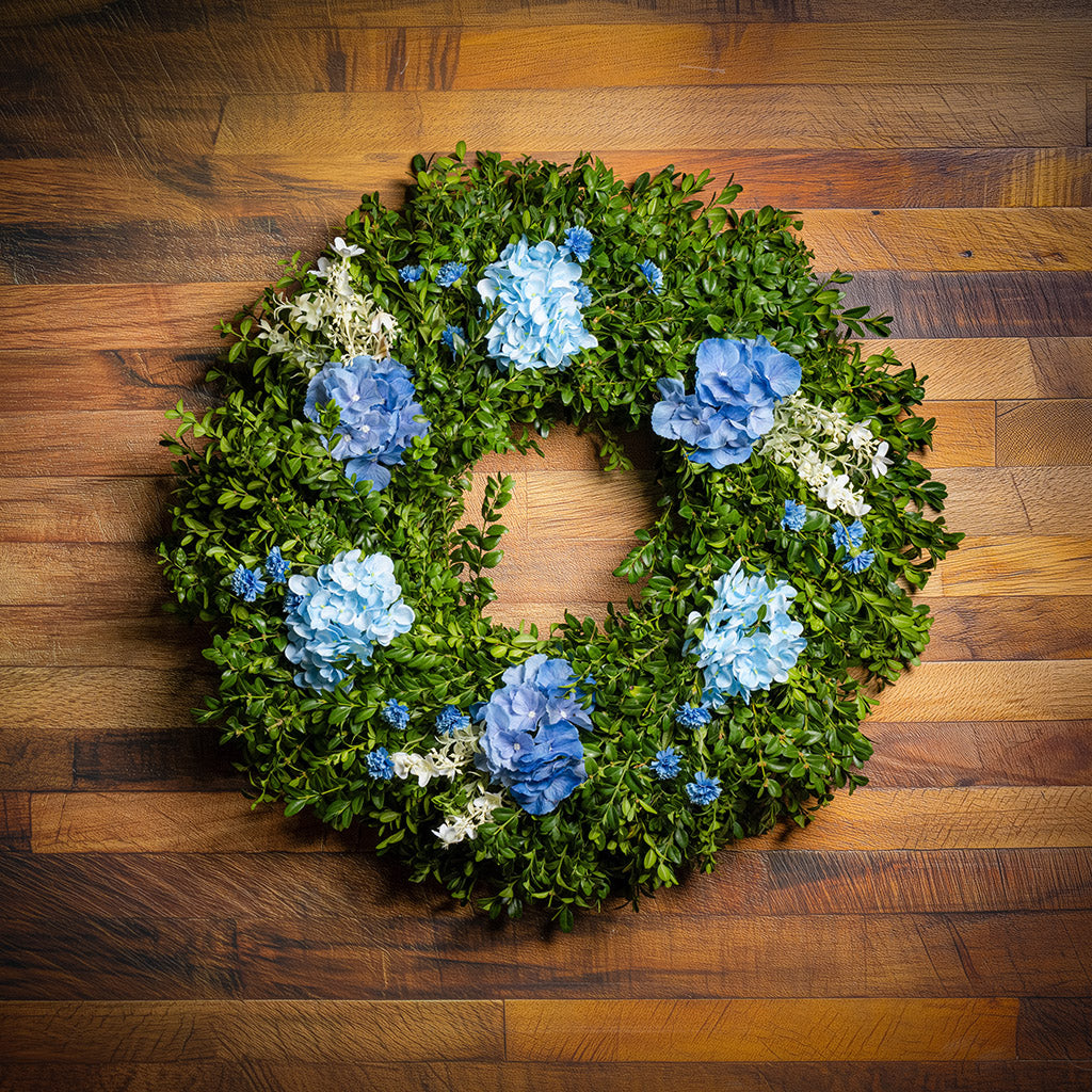 Fresh boxwood with faux blue hydrangeas and blue statice flowers