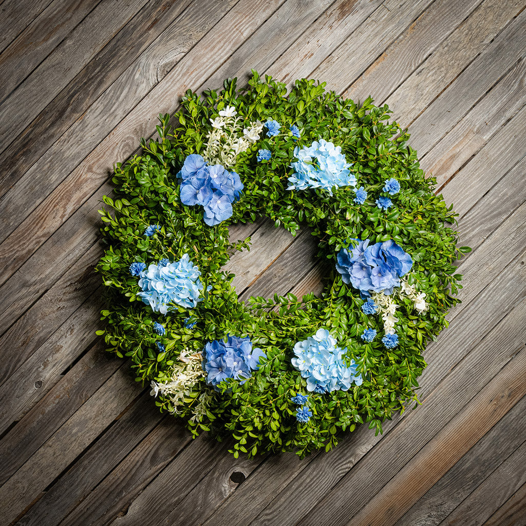 Fresh boxwood with faux blue hydrangeas and blue statice flowers