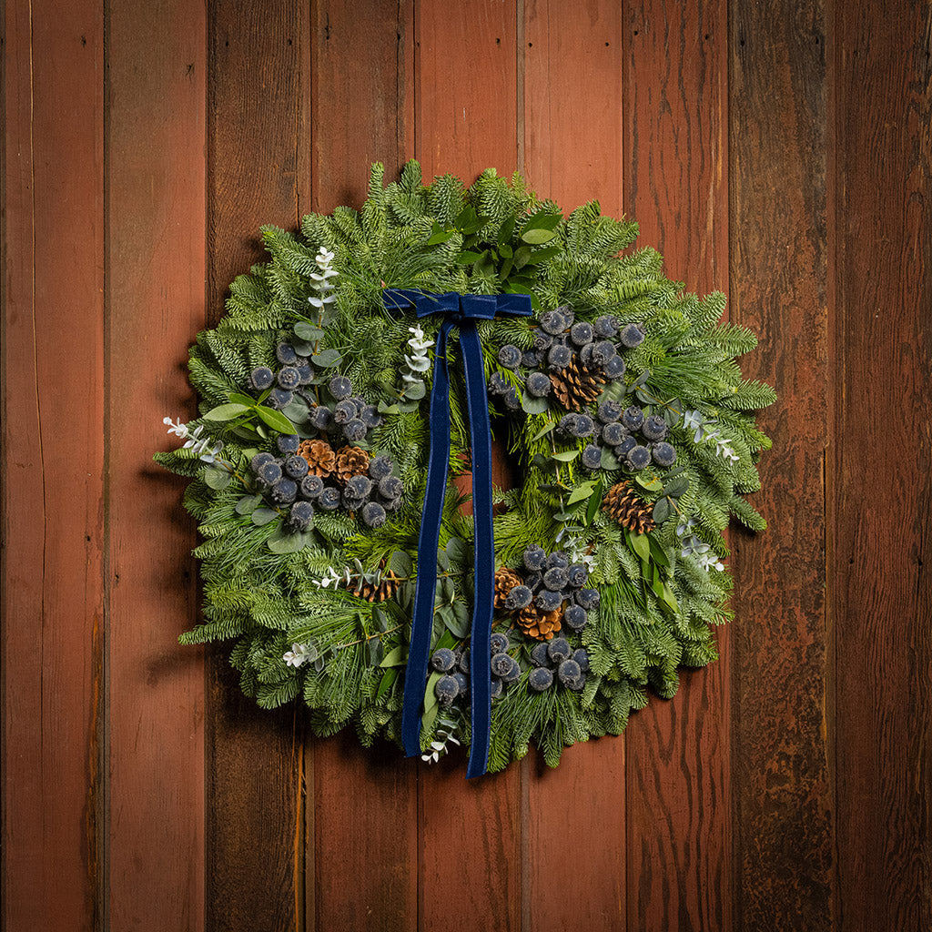 Green wreath with blue ribbon on a wooden door