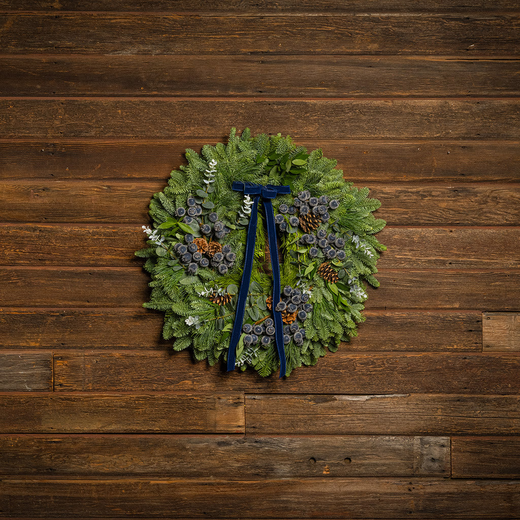 Green wreath with decorative elements on a wooden background