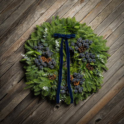 Green wreath with decorative elements on a wooden surface