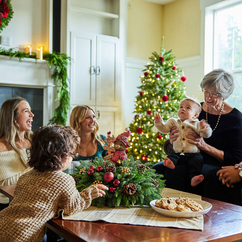 Family gathered around a Christmas tree in a cozy living room.