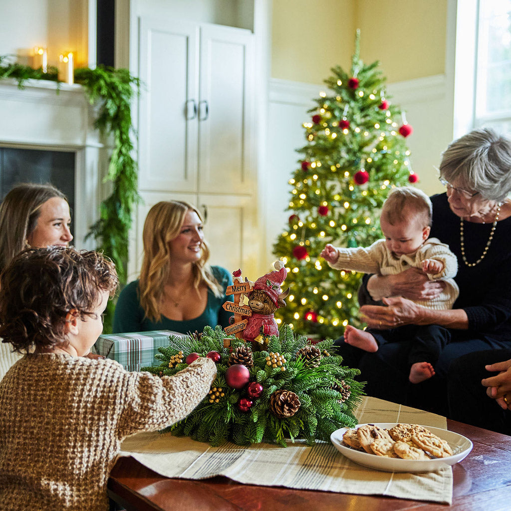 Family gathered around a Christmas tree in a cozy living room.
