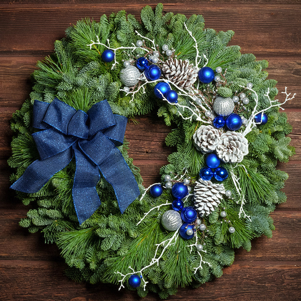 Blue and white decorations with blue bow on evergreen wreath