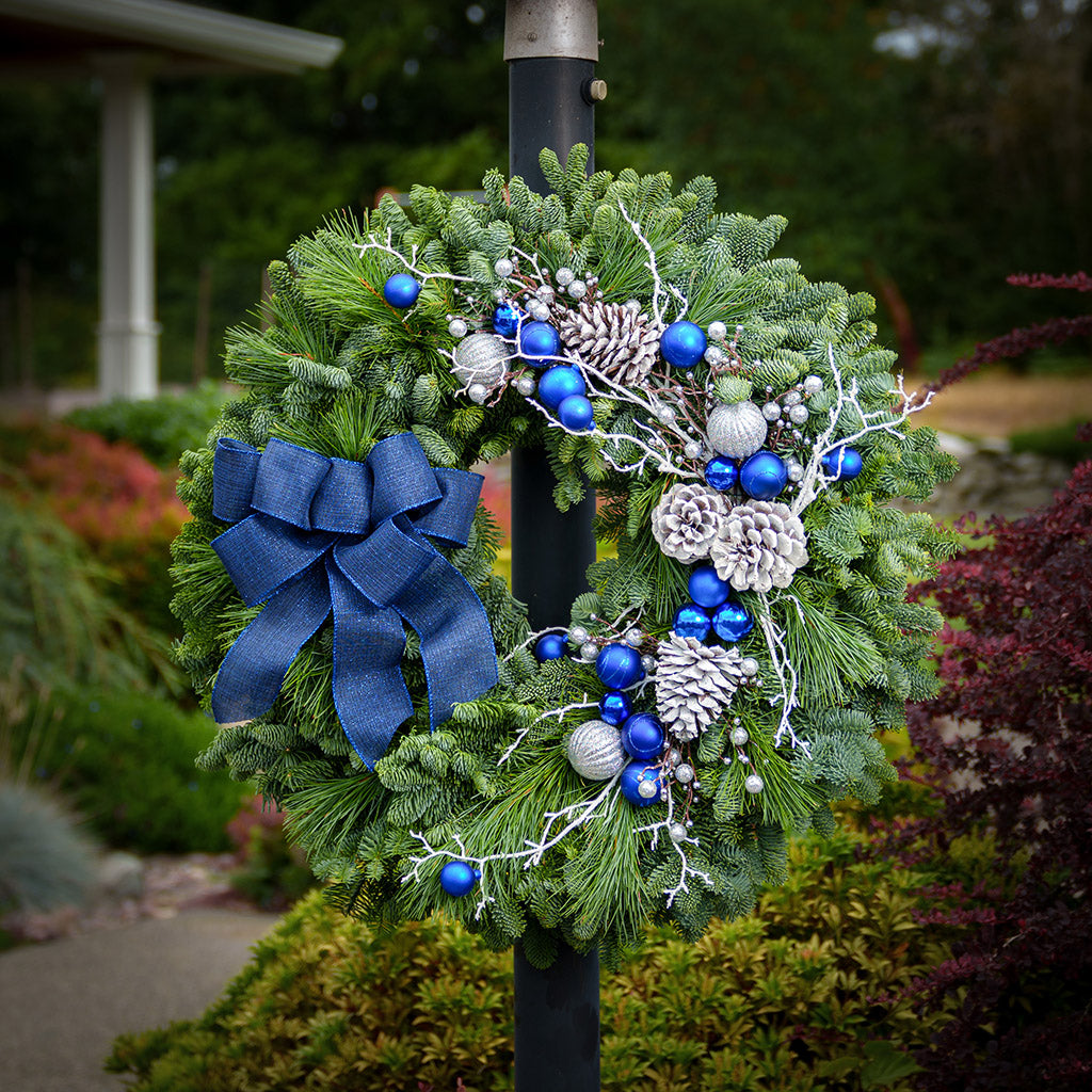 Blue and white decorations with blue bow on evergreen wreath