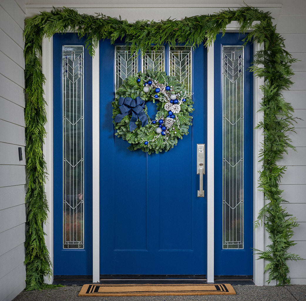 Blue and white decorations with blue bow on evergreen wreath