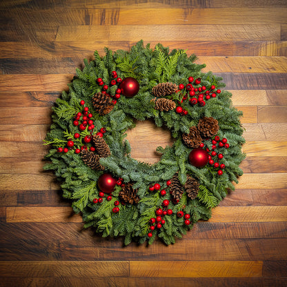 Christmas wreath with red berries and pine cones on a wooden background