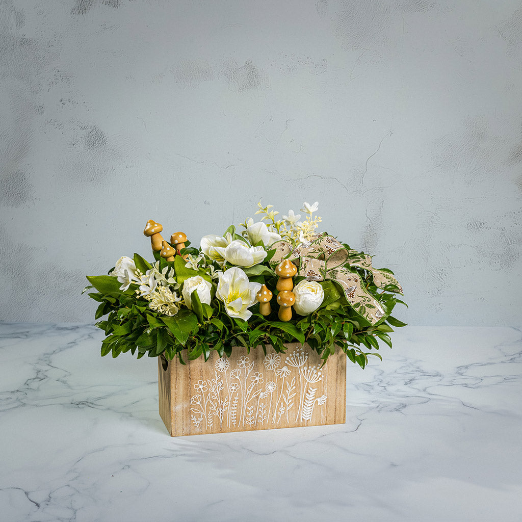 Fresh salal and green huckleberry with faux white tulips, faux white small flowers, faux white hellebores flowers, faux wood mushrooms, and a fern & mushroom bow in a wildflower-themed wooden box