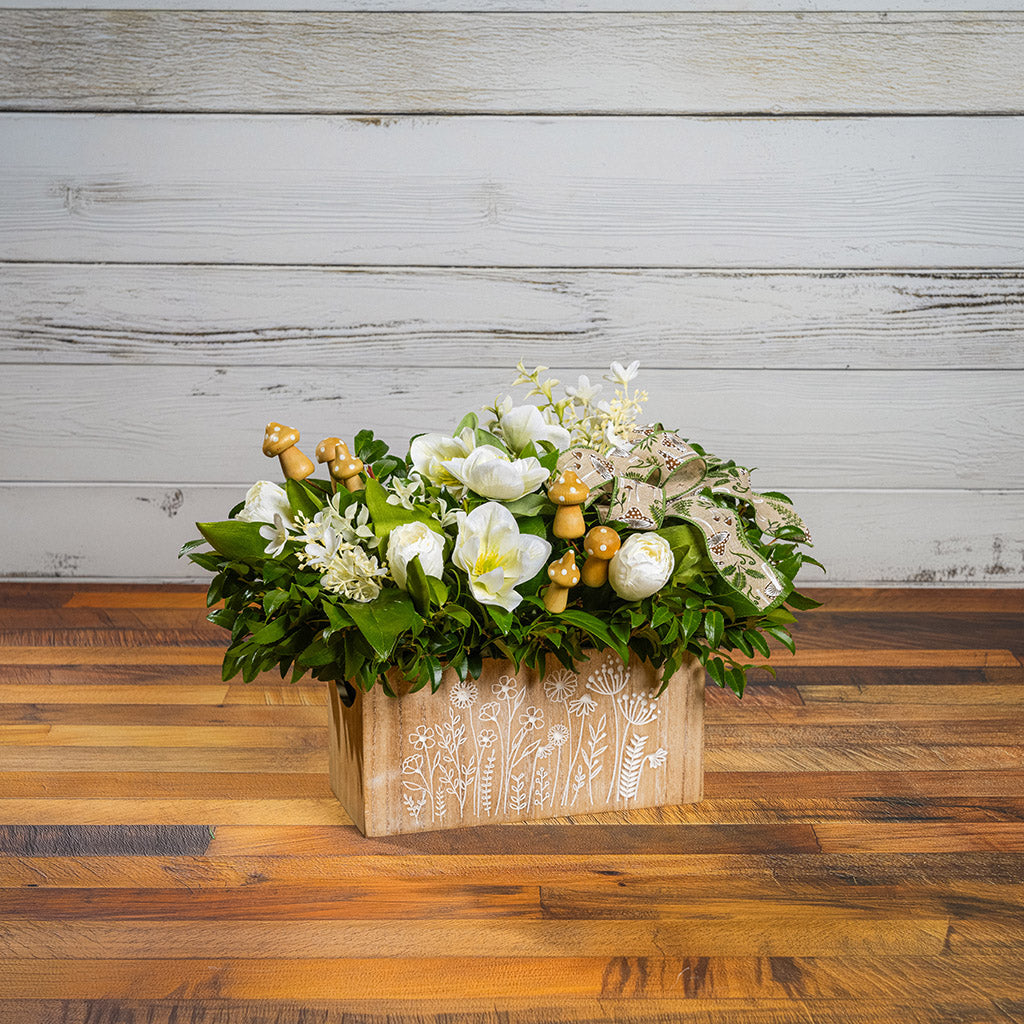 Fresh salal and green huckleberry with faux white tulips, faux white small flowers, faux white hellebores flowers, faux wood mushrooms, and a fern & mushroom bow in a wildflower-themed wooden box