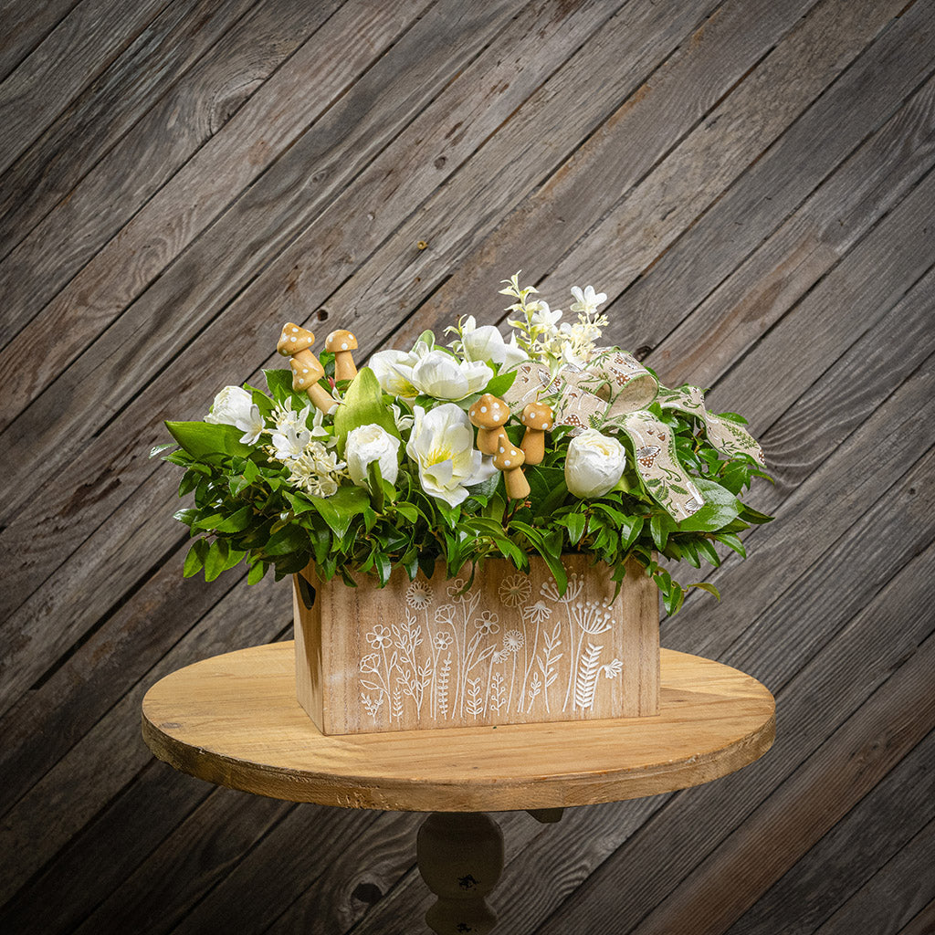 Fresh salal and green huckleberry with faux white tulips, faux white small flowers, faux white hellebores flowers, faux wood mushrooms, and a fern & mushroom bow in a wildflower-themed wooden box