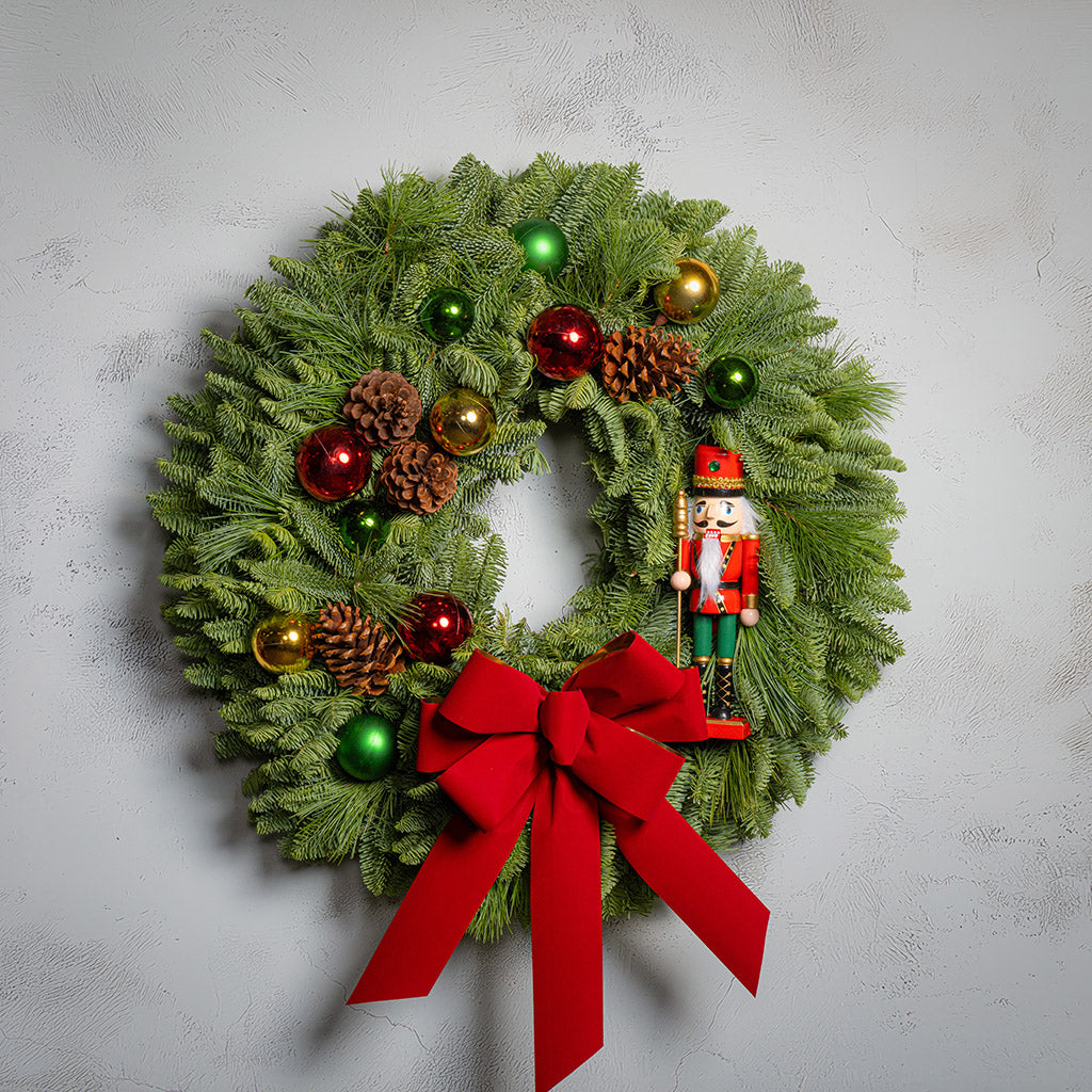 Decorative Christmas wreath with ornaments on a light gray background