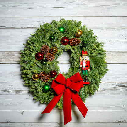 Christmas wreath with ornaments and a red bow on a wooden background