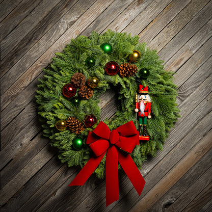 Christmas wreath with red bow and ornaments on a wooden background